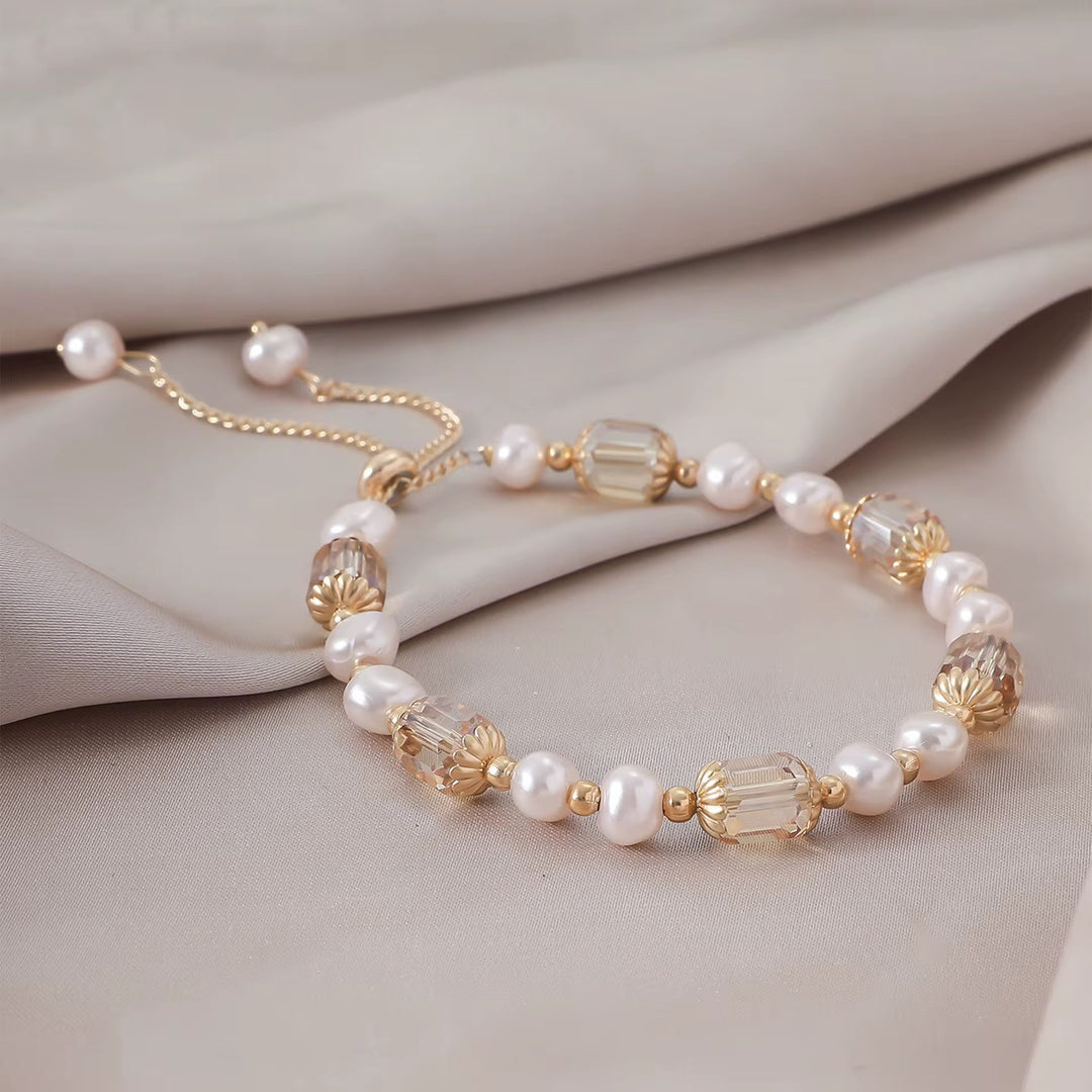 Edles Armband in Champagner mit schimmernden Zierperlen und vergoldeten Elementen.