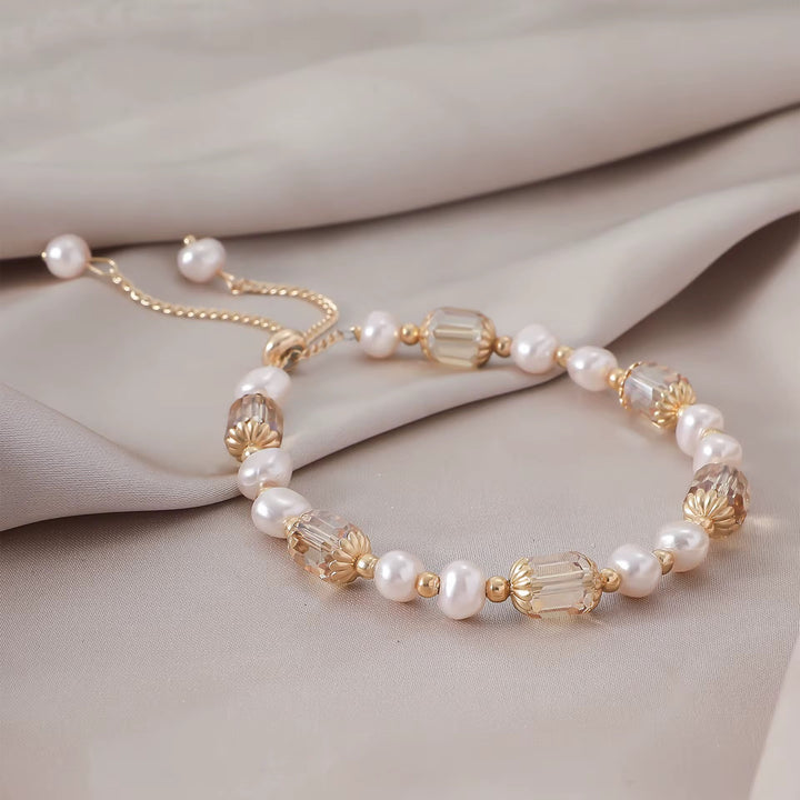 Edles Armband in Champagner mit schimmernden Zierperlen und vergoldeten Elementen.