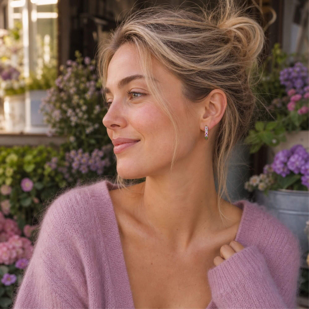 Frau trägt BLOSSOM GLOW Hoops in Pink von TREND Kollektiv – vergoldete Huggie Ohrringe mit pinker Emaille – AI-GENERATED