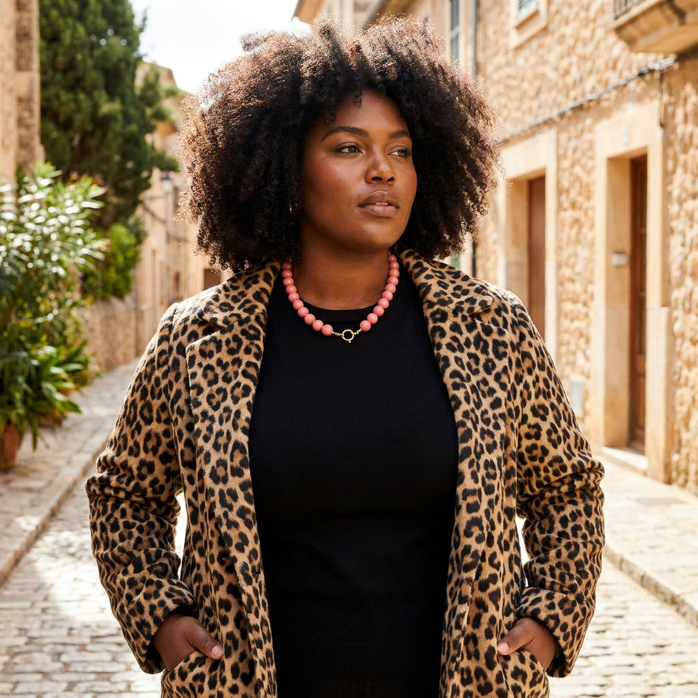 Farbige Plus Size Frau trägt die Bold Beads Halskette in Koralle – AI-GENERATED