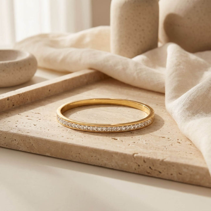 Moodbild vom GRACE Bangle, liegend auf einem strukturierten Marmorstein im Hintergrund sieht man Vasen und Leinentücher