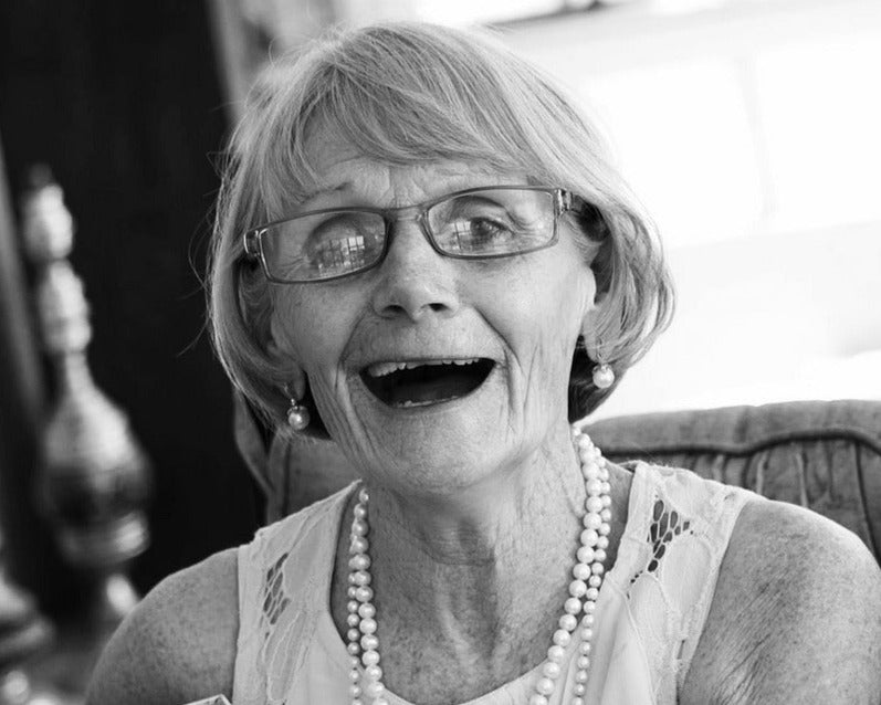 Glueckliche Oma mit Perlenkette und Brille