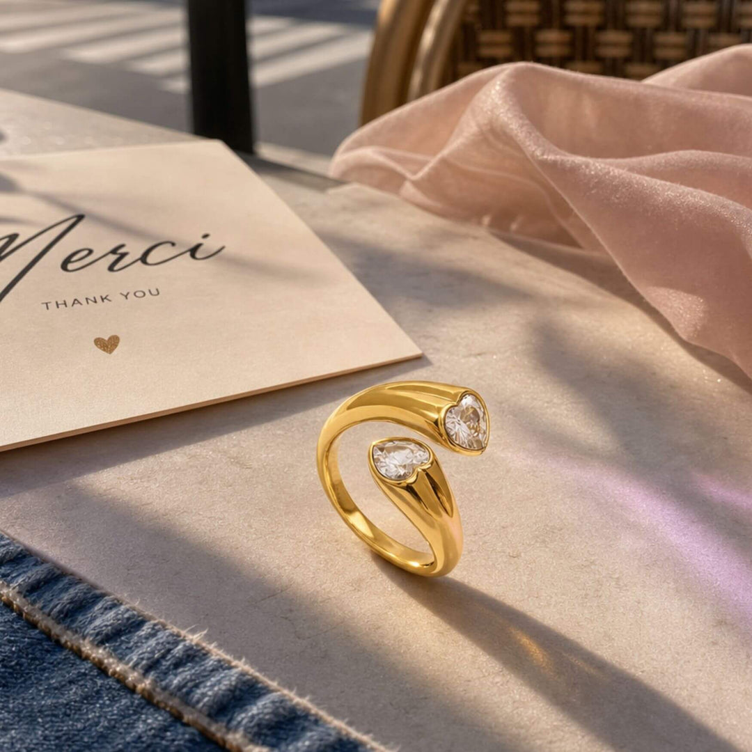 Duo Hearted Ring in Gold auf einem Tsch insziniert als Moodbild in Gold an der Hand eines Models – AI-GENERATED