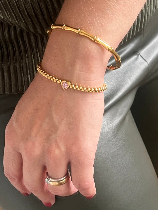 Imagebild einer Frauenhand die den Bamboo Bangle und das Heartbeat Rosé Armband von TREND Kollektiv trägt