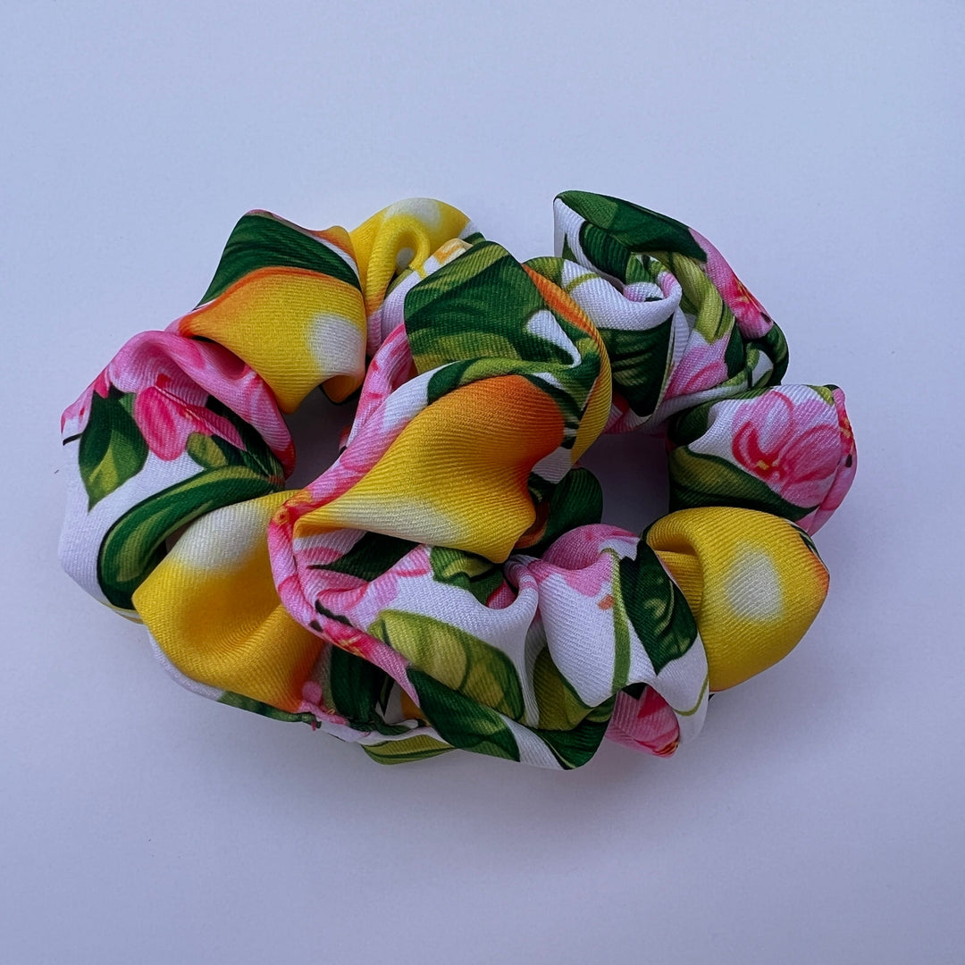 Das Lemon Garden Scrunchie von TREND Kollektiv ist hanbdgenäht und zeigt auf einem Baumwoll-Twill Stoff sizilianische Zitronen mit Blattgrün und rosé farbenen Blüten