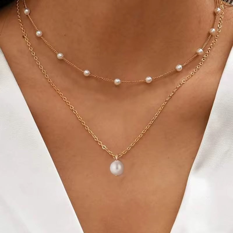 Goldene Layerkette mit zarten Zierperlen und Tropfenanhänger – feminin & elegant.