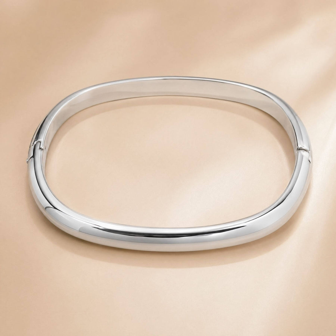Noa Bangle in silber als Freisteller auf einem beigen Hintergrund präsentiert von TREND Kollektiv