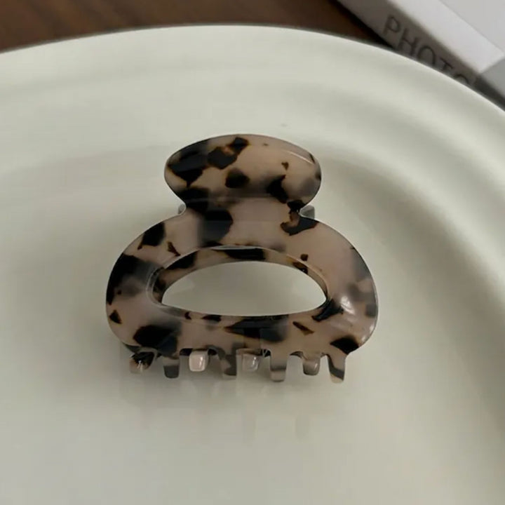 Detailbild des SOFT Leo Mini Haarclip von TREND Kollektiv arrangiert auf einer weißen Porzellanplatte
