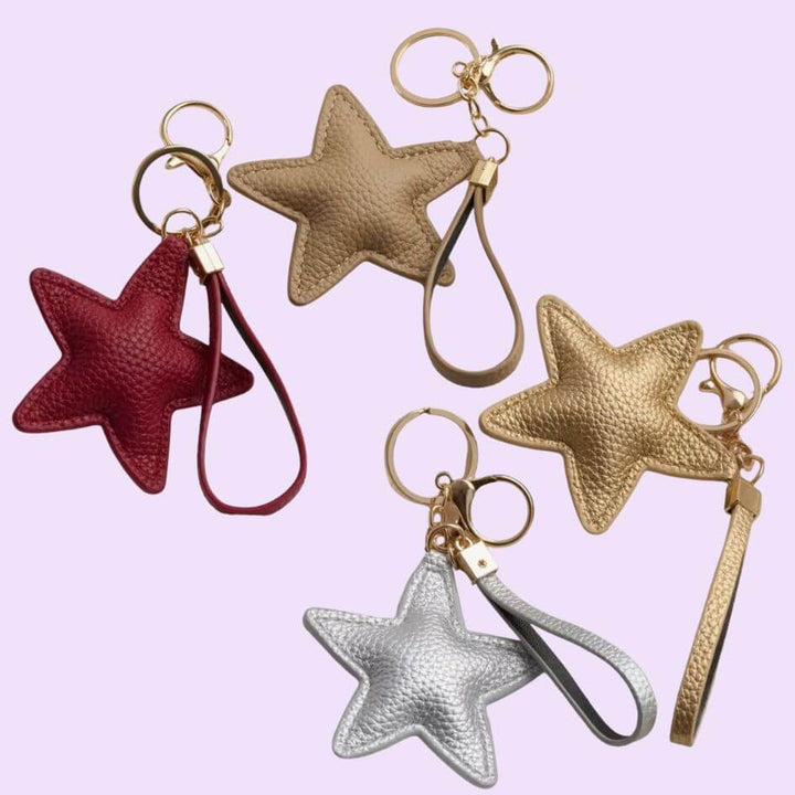 STAR TOUCH Taschenanhänger Sterne in Rot, Beige, Schwarz, Silber und Gold an einer Handtasche – TREND Kollektiv