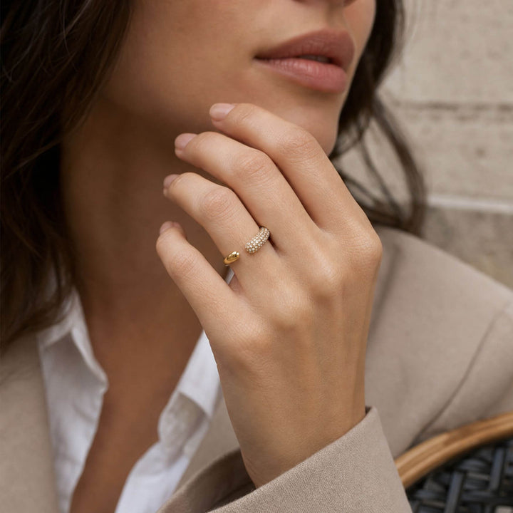 Nahaufnahme einer Hand eines Models die den Spakle Arc Ring in Gold von Trend Kollektiv trägt – AI-GENERATED
