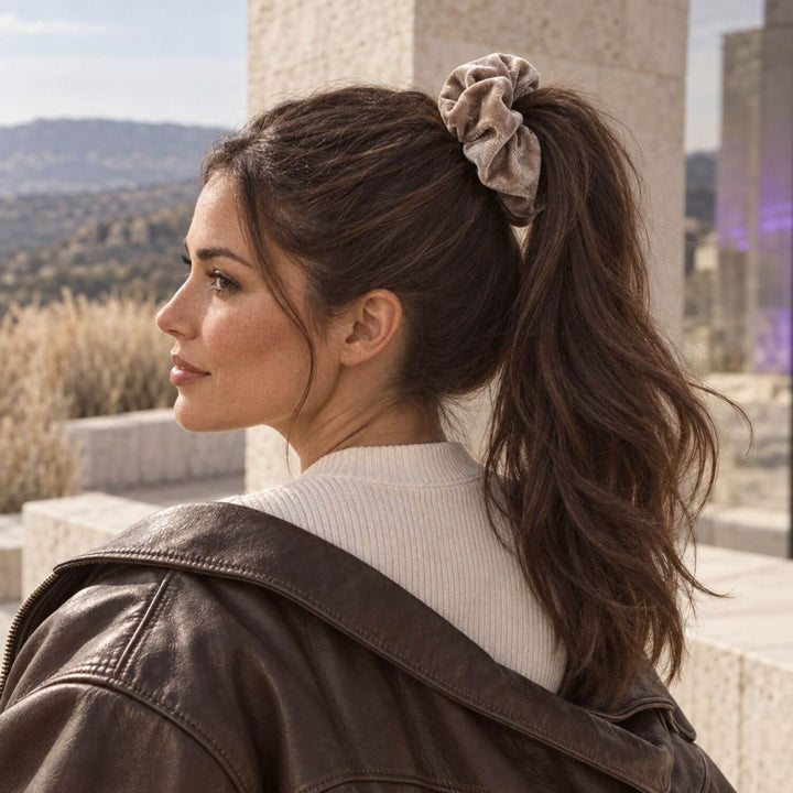 Großes greiges Samt-Scrunchie im voluminösen Pferdeschwanz eines dunkelhaarigen Models von TREND Kollektiv – AI-GENERATED