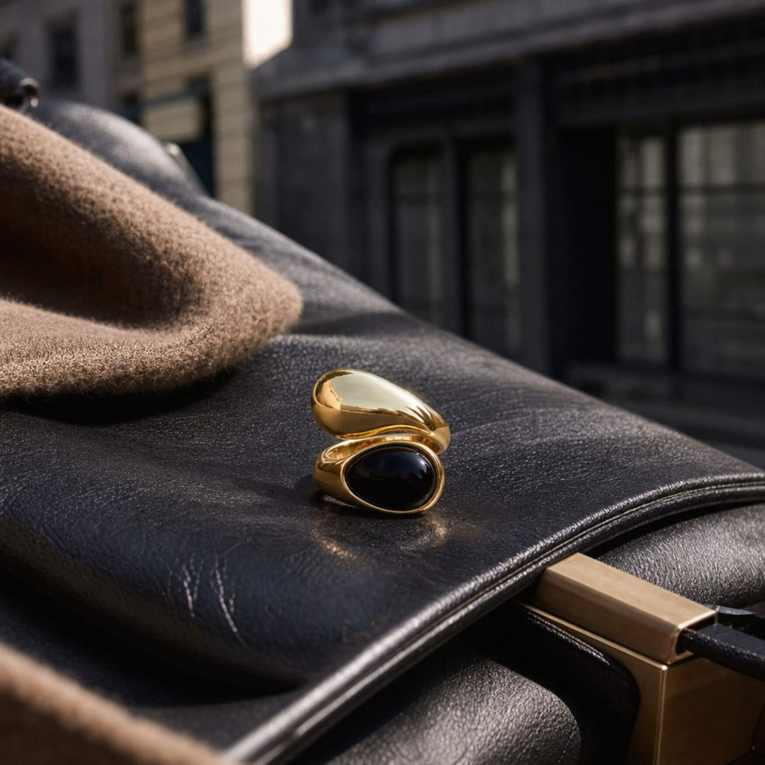 AURA STONE Ring in Black auf dunklem Stoff und hellem Stein inszeniert – AI-GENERATED