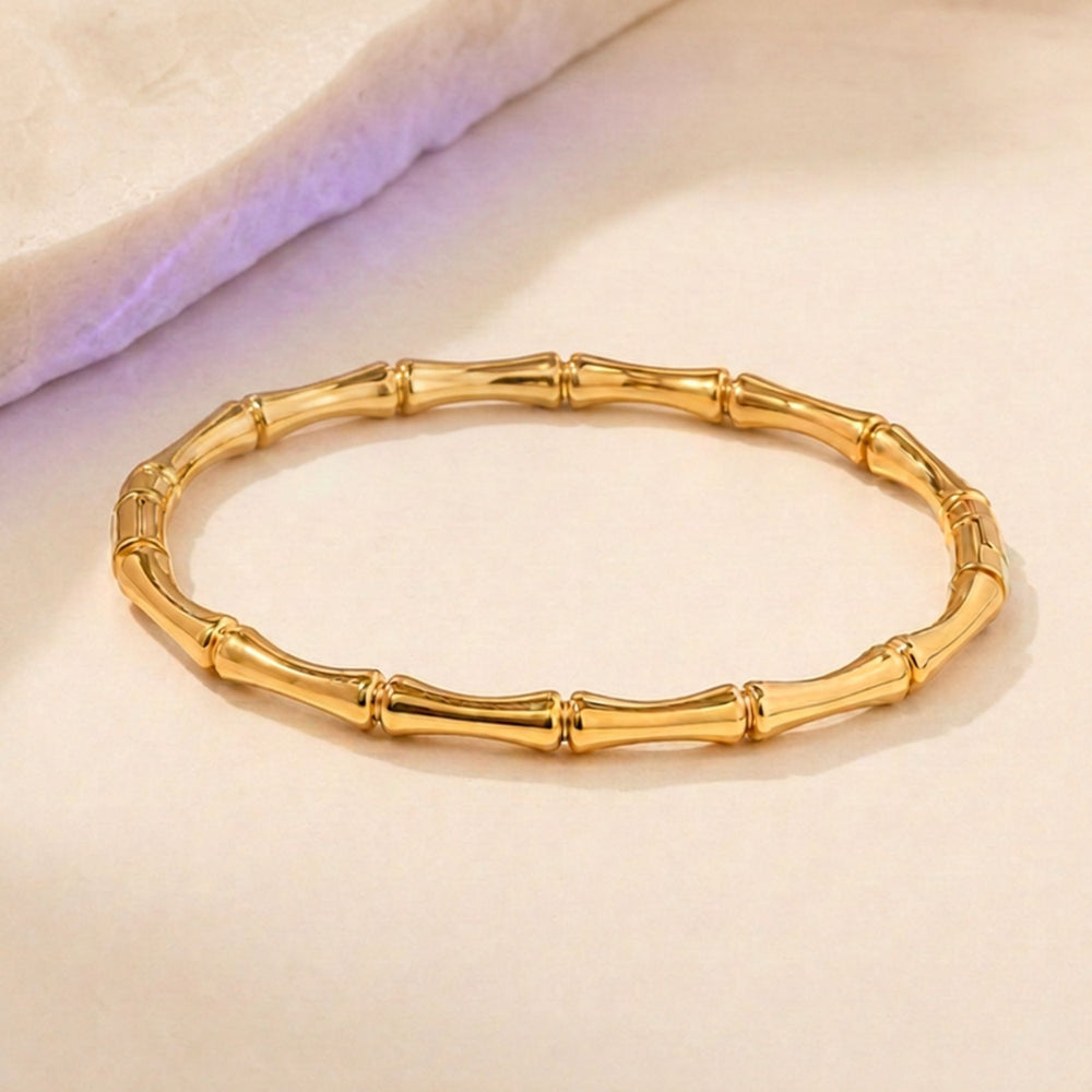 BAMBOO Bangle aus Edelstahl mit 18K-Vergoldung auf beigen Hintergrund – AI-GENERATED