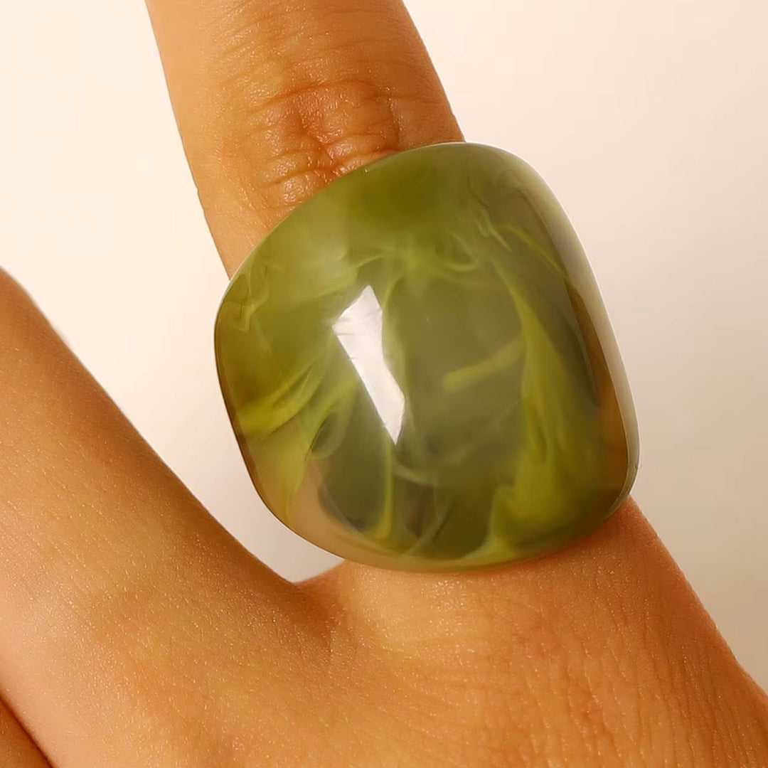 Frau trägt den breiten TERRA Resin Ring in Olive an einem Finger