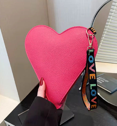 Pinkfarbene Mini-Handtasche in Herzform mit LOVE-Tragegurt – stilvoll & verspielt von TREND Kollektiv