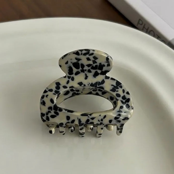 Detailbild vom MONO-STONE-MiniHaarclip arrangoert auf einer weißen Porzellan Platte – AI-GENERATED