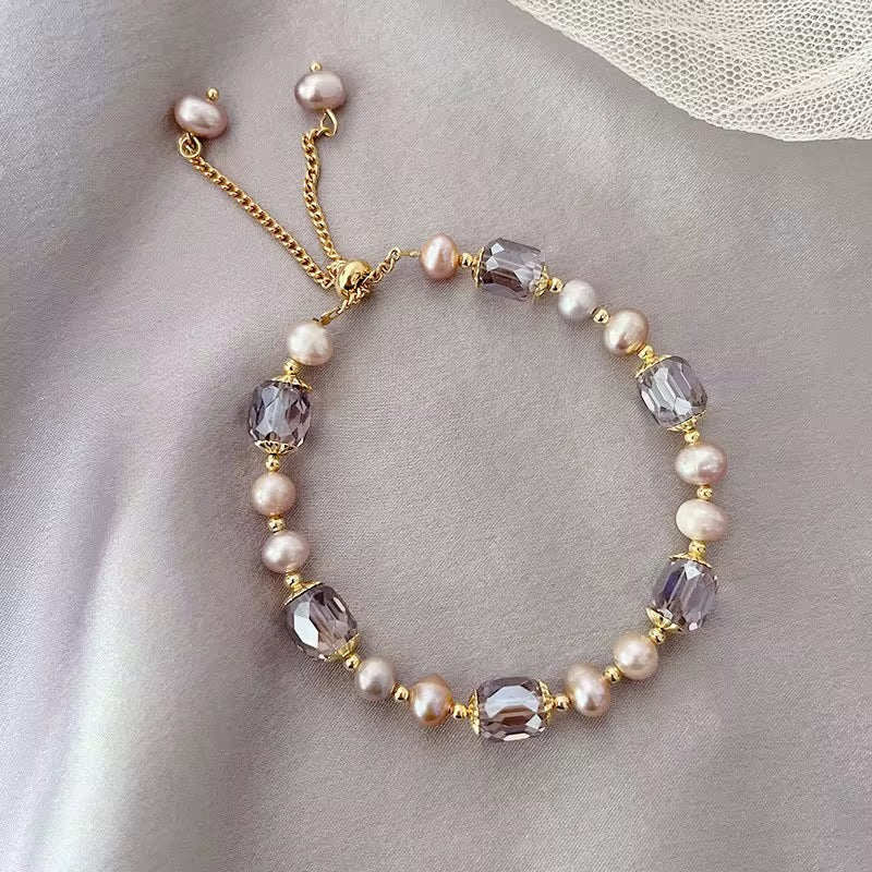 Funkelndes Armband in Violett mit Kristallen, goldenen Details und Perlen im Barock-Stil.
