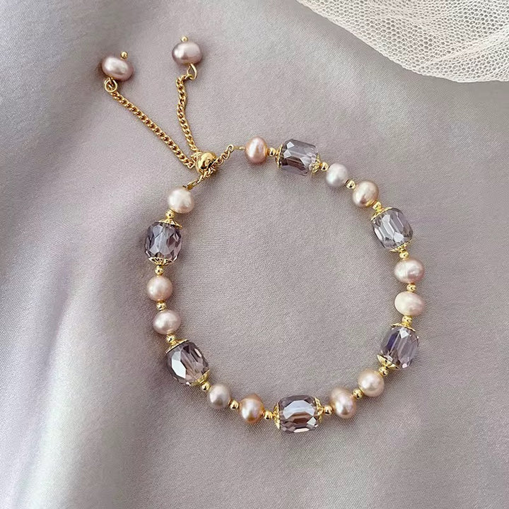 Funkelndes Armband in Violett mit Kristallen, goldenen Details und Perlen im Barock-Stil.