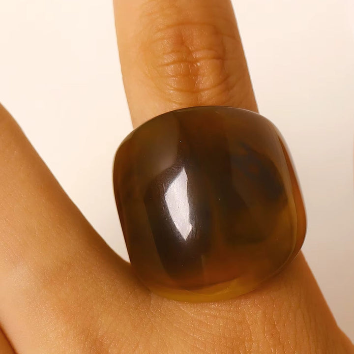Frau trägt den breiten TERRA Resin Ring in Mocha an einem Finger
