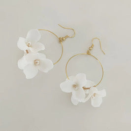 Handgemachte goldene Creolen mit weißen Emaille-Blüten – stilvoll und elegant, ideal für Sommerlooks.