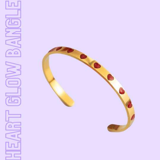 HEART GLOW 18k Bangle mit roten Emaille-Herzen auf heller Unterlage neben rosa Notizbuch – TREND Kollektiv