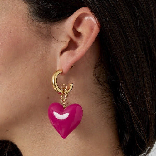 Pinkes HEART GLOW Herz-Ohrring-Paar an goldener Creole am Ohr getragen – TREND Kollektiv
