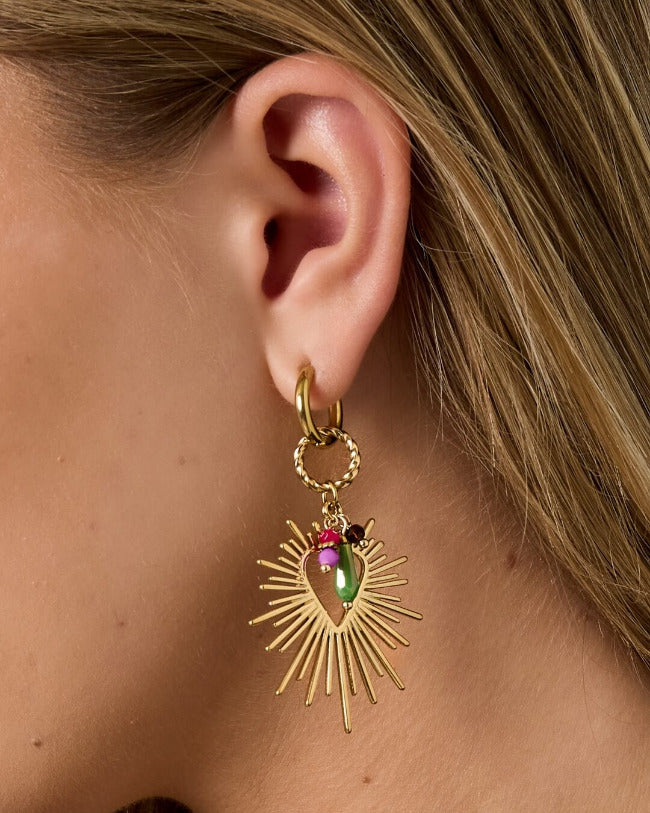 Nahaufnahme der SUNRAY HEART Hoops – goldfarbener Herz-Sunray-Anhänger mit pinken und grünen Charms am Ohr