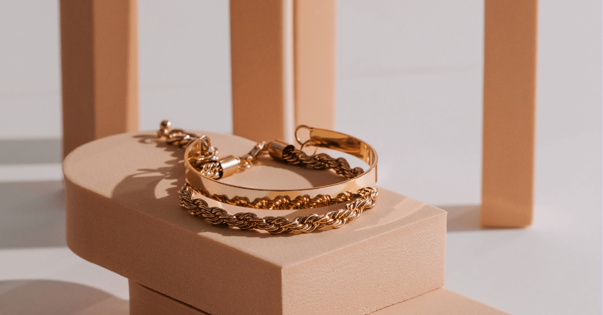Vergoldete Armbänder von TREND Kollektiv auf modernem Podest – perfekter Look für Layering & Selfcare
