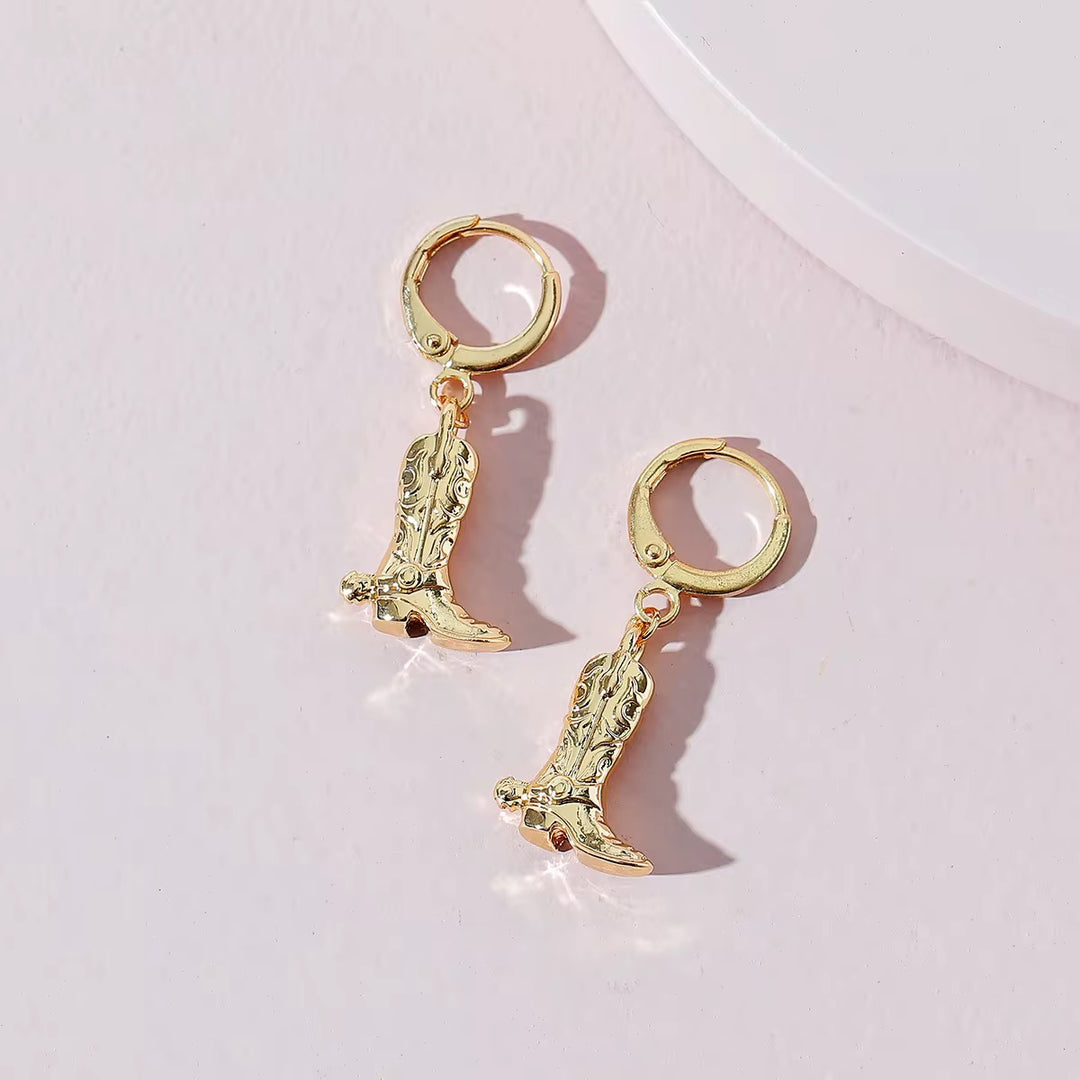 Creolen mit kleinen Cowboy-Boot-Anhängern in glänzendem Gold – verspielt & trendbewusst.